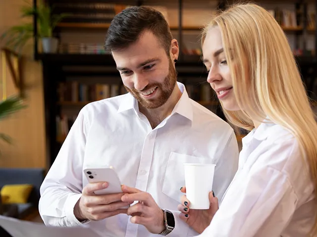 Ein Mann und eine Frau in Gastro-Kleidung besprechen gemeinsam etwas.