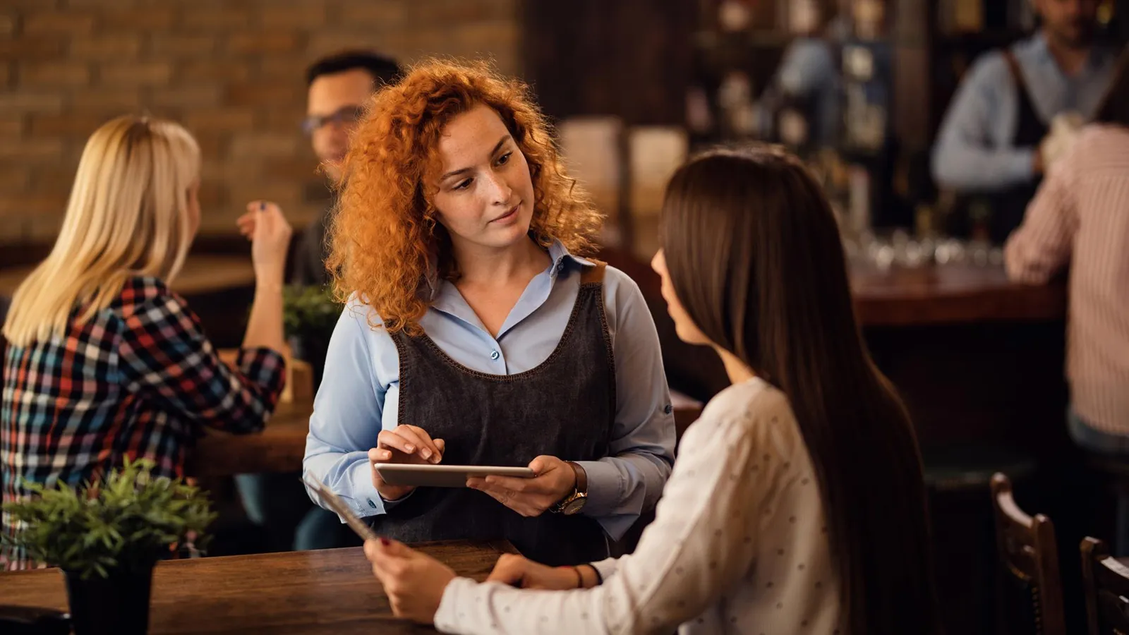 Blogartikel Titelbild: eine weibliche Bedienung nimmt eine Bestellung auf